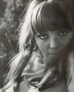 Mickey Jines close-up in black and white, recognizable face from Russ Meyer films.